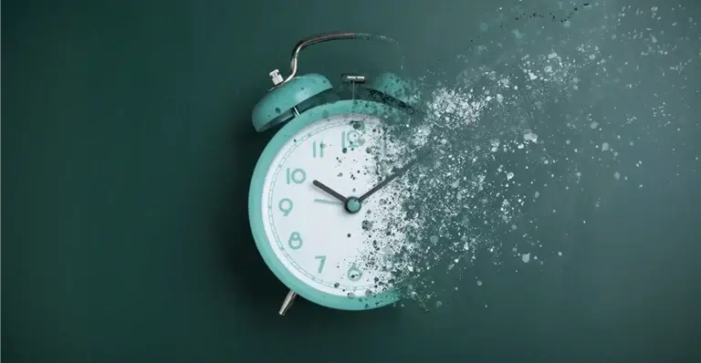 Abstract image of an alarm clock partially dissolving into particles representing the contrast between continuous compliance monitoring and point in time audits